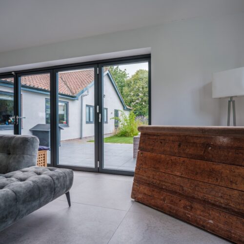 Modern,Furnished,Living,Room,With,Bifold,Patio,Doors,Leading,To
